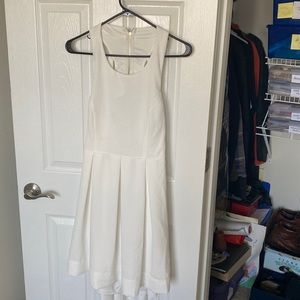 White dress with open back. Lightly used, one small stain on the front